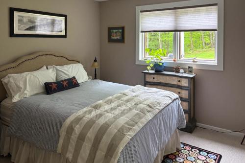 a bedroom with a bed and a window and a dresser at River Haven in Newfane