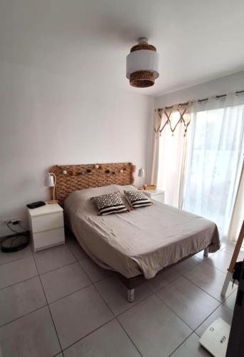 une chambre avec un lit et une grande fenêtre dans l'établissement La Maison de Cathy, à Pérols