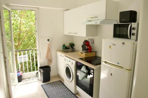 une cuisine avec un réfrigérateur et une machine à laver dans l'établissement Appartement à 5 min de la plage Soleil & Confort, à Nice