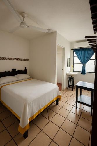 een slaapkamer met een groot bed en een tafel bij Hotel Casa Zoque Colonial in Tuxtla Gutiérrez
