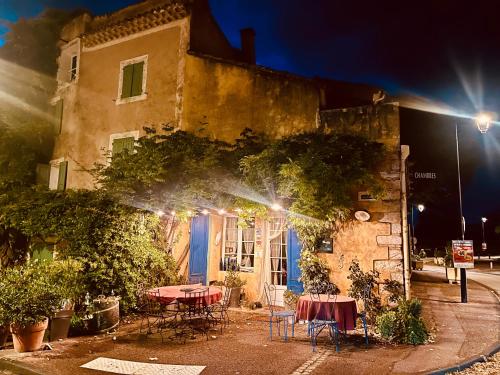 a building with tables in front of it at night at La Sarrasine in Villes-sur-Auzon