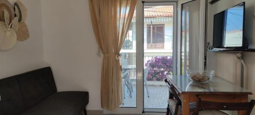 a living room with a table and a sliding glass door at Summer place Pefkohori in Pefkohori
