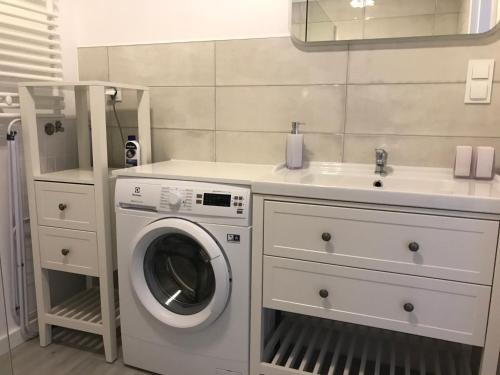 a bathroom with a washing machine and a sink at Oaza spokoju in Jastrzębia Góra