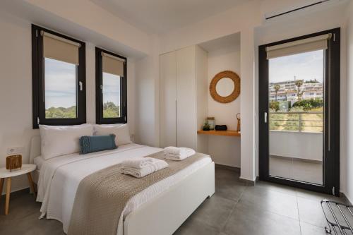 a bedroom with a white bed with two towels on it at Casa al Mare in Nea Roda