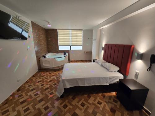 a bedroom with a bed and a tub and a sink at Hostal Prestigio in Lima