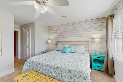 Un dormitorio con una cama y un ventilador de techo. en Holiday Zen, en Carolina Beach