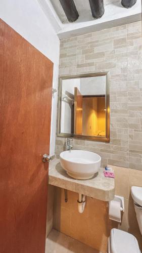 a bathroom with a sink and a mirror and a toilet at Casa Santa María Valladolid in Valladolid