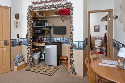 a room with a kitchen with a refrigerator and a table at Alaska's Harvest Bed and Breakfast and Luxury Log Cabin in Palmer