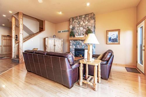 a living room with two leather couches and a fireplace at Incredible Views w Garage on Lake and bike trail in Tofte