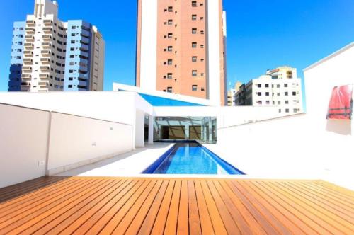 a pool on the roof of a building with buildings at Refúgio Manhattan Flat - Silencio, espaço e ao lado do shopping in Campo Grande