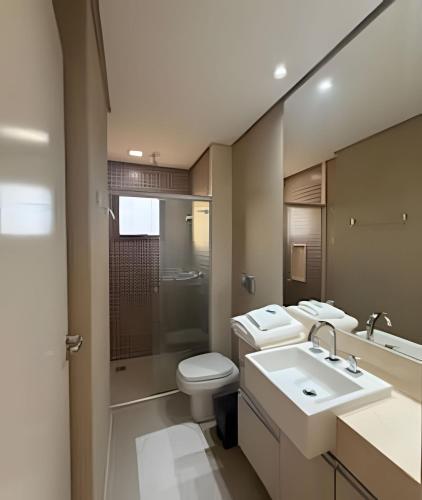 a bathroom with two sinks and a toilet and a shower at Refúgio Manhattan Flat - Silêncio, espaço e ao lado do shopping in Campo Grande