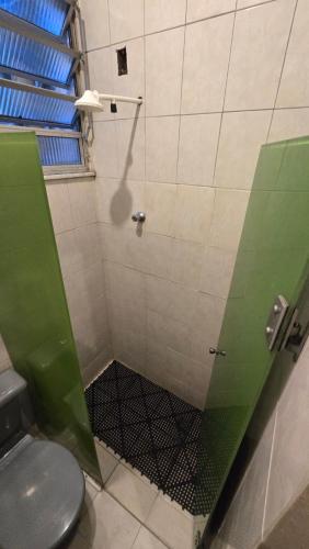 a bathroom with a shower with a green glass door at Hostel & Privativo in Manaus