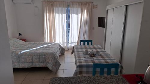 a hotel room with a bed and a table and chairs at Depto moderno en pleno centro in Rosario