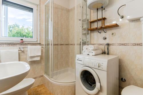 a bathroom with a washing machine and a sink at Beverly Klis House in Klis