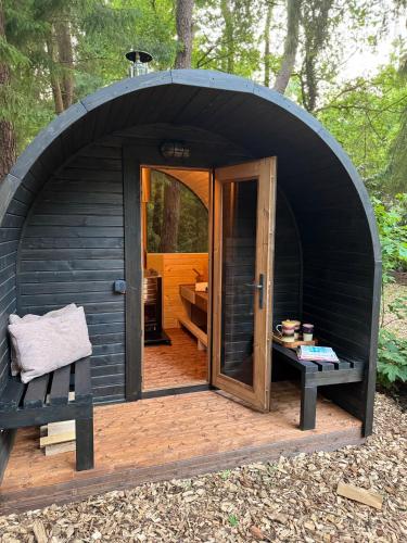 a black dome tent with a bench and a door at Heeren van Norg in Norg