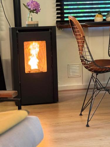 a fireplace in a living room with a chair at Heeren van Norg in Norg