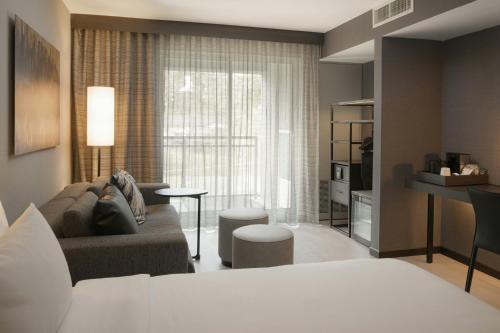 a room with a couch and a living room with a window at AC Hotel Asheville Biltmore Village in Asheville