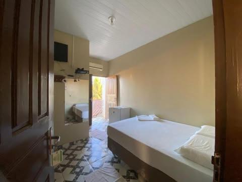 a bedroom with a white bed in a room at Junior Hotel in Anapu