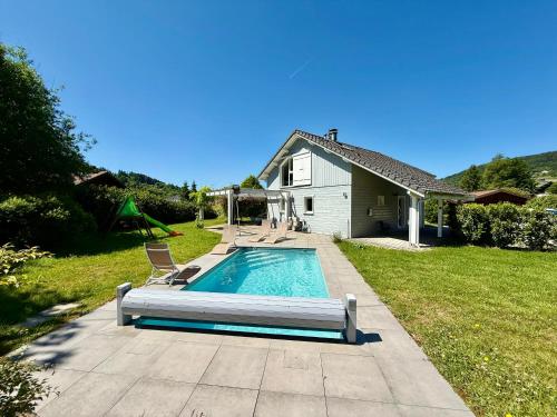 une piscine dans la cour d'une maison dans l'établissement Le Jardin de Rose et Capucine, piscine et jardin avec terrasse, à Gérardmer
