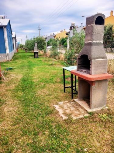 a pizza oven sitting on top of a grass field at HAPPY LİFE HOUSES in Ürkmez