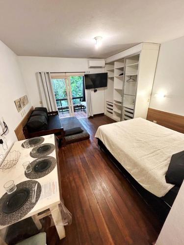 a bedroom with a bed and a living room at Maresias flat mata azul in Maresias