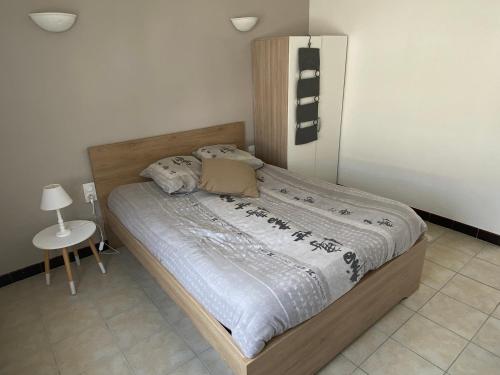 une chambre avec un lit avec une tête de lit en bois dans l'établissement F3 patio bien situé, à Canet