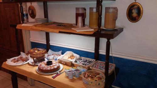 uma mesa com comida e bebidas numa prateleira em Hotel Sangiuliano 132 centro storico Catania em Catânia