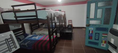 a room with bunk beds in a room with a door at Backpackers Oruro B&B in Oruro