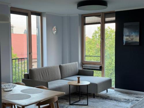 a living room with a couch and a table at MANTO NAMAI apartment in the center of Klaipeda with a view in Klaipėda