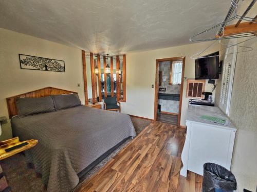 a bedroom with a large bed and a kitchen at Cedar Wood Inn in Deadwood