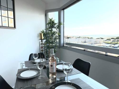 - une table à manger avec des verres à vin et une fenêtre dans l'établissement Appartement lumineux avec vue sur le port, plage à 10 min à pied - Proche tout commerces, à Mauguio
