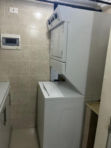 a small kitchen with a white refrigerator with a stove at Apartment in Bello in Medellín