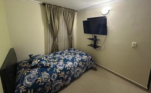 a bedroom with a bed and a tv in it at Apartment in Bello in Medellín