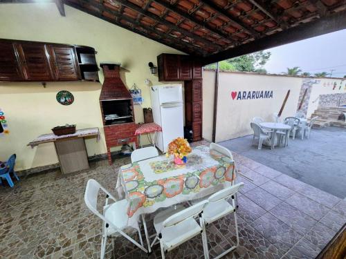 a room with a table and chairs and a stove at Casa em Condomínio com Piscina Privativa in Araruama