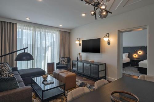 a living room with a couch and a room with a bed at The Vanguard Ann Arbor, Autograph Collection in Ann Arbor