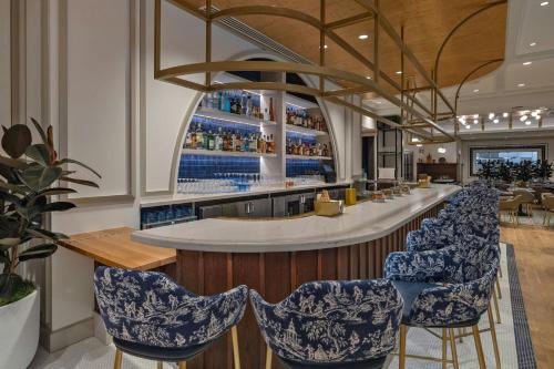 a bar with blue and white chairs in a restaurant at The Vanguard Ann Arbor, Autograph Collection in Ann Arbor