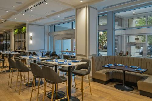 a restaurant with tables and chairs and windows at The Vanguard Ann Arbor, Autograph Collection in Ann Arbor