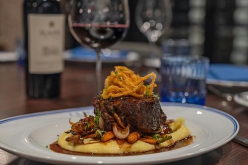 a plate of food on a table with a glass of wine at The Vanguard Ann Arbor, Autograph Collection in Ann Arbor