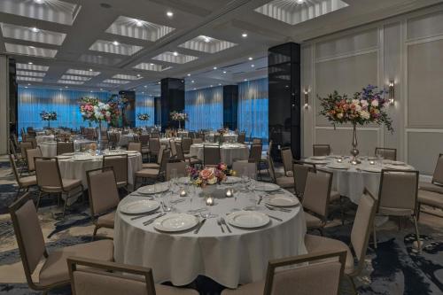 a banquet hall with white tables and chairs and flowers at The Vanguard Ann Arbor, Autograph Collection in Ann Arbor