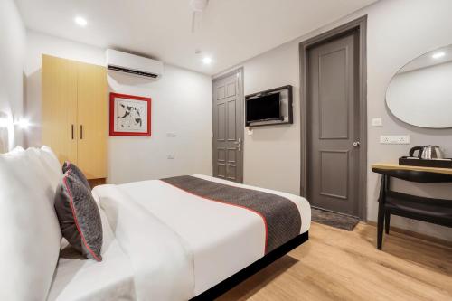 a bedroom with a bed and a desk and a sink at Super Townhouse 158 Near Netaji Subhash Marg Near Appu Ghar in Gurgaon
