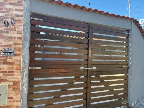 a wooden garage door on the side of a building at Casa com piscina climatizada em Itanhaém! in Itanhaém