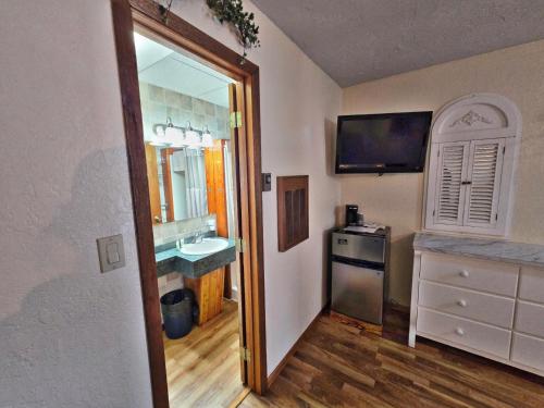 a small bathroom with a sink and a mirror at Cedar Wood Inn in Deadwood