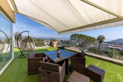 d'une terrasse avec une table, des chaises et une balançoire. dans l'établissement 06 Bl - Superb contemporary villa with sea view, à Villeneuve-Loubet
