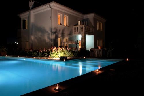 uma piscina em frente a uma casa à noite em Una Stanza nel Parco em Ariano nel Polesine