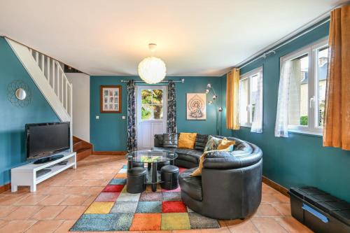 un salon avec un canapé et une télévision dans l'établissement La Hulotte - Paisibilité et Patrimoine, à Vaux-sur-Aure