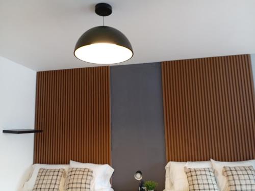 a bedroom with a bed and a light fixture at OAK 3B Loft Ejecutivo con Balcón in Estación Pamplona