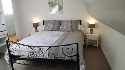 - un lit dans une chambre avec 2 lampes sur 2 tables dans l'établissement L'escapade Landaise, Confort, Plage et Soleil, à Dax