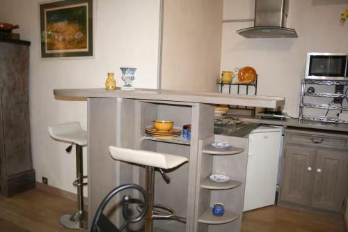 a kitchen with a counter and some stools in it at Havre de paix avec vue mer in Le Lavandou