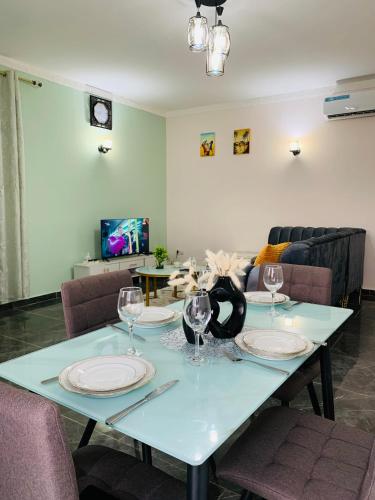 einen Tisch mit Tellern und Weingläsern darauf in der Unterkunft Cosy Home By Djoles in Jaunde