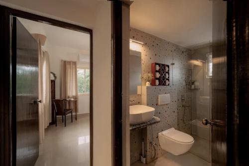 a bathroom with a toilet and a sink at CasaKai 2BHK Bohemian Spread with 3 Patios & Pool, Near Thalassa in Siolim
